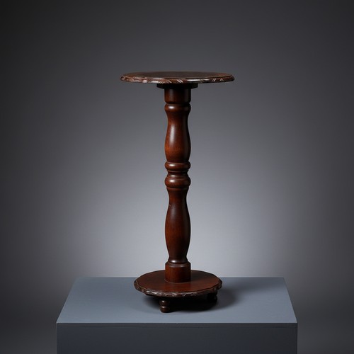 427 - A carved hardwood pedestal occasional table, the circular top and base with leaf-moulded gadrooned e... 