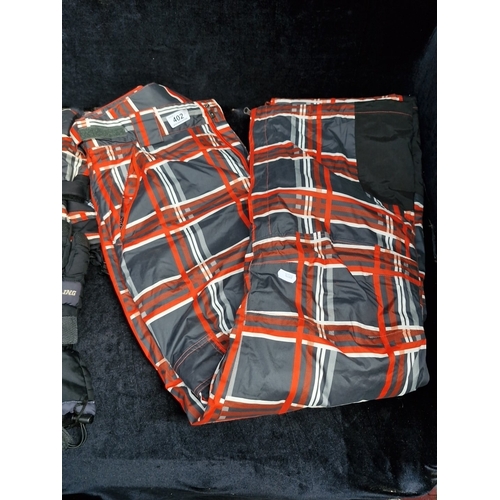 402 - A group of winter sports outerwear, comprising a red, grey and black tartan-patterned jacket, matchi... 