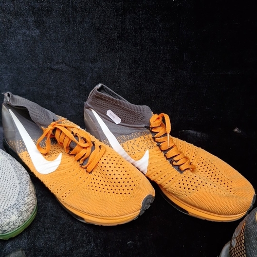 405 - A group of assorted footwear, comprising Nike Flyknit running shoes, Nike knit trainers, Adidas trai... 
