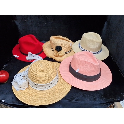 407 - A group of fashion hats, including felt and woven paper styles, comprising a red fedora, straw sunha... 