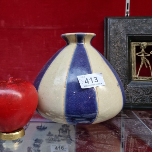 413 - A group of decorative objects, including a blue-and-cream striped glazed ceramic vase, a carved wood... 