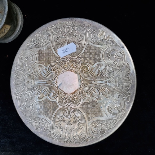 415 - A group of assorted decorative items, including an engraved circular metal salver, a small pewter mu... 