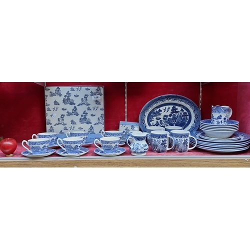 416 - A group of Churchill Blue Willow pattern blue-and-white tableware, including cups and saucers, dinne... 