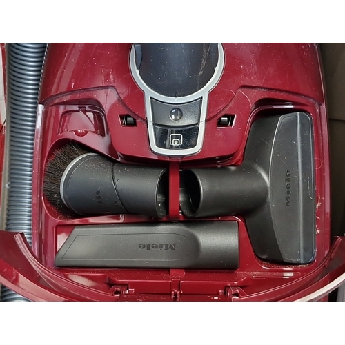 419 - A Miele Complete C3 “Cat & Dog” PowerLine canister vacuum cleaner, in maroon, with hose, telescopic ... 