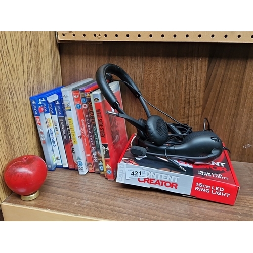 421 - A group of PlayStation 4 video games and assorted DVD films, with a USB headset and a boxed 16cm LED... 