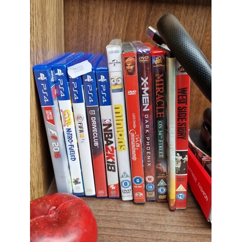 421 - A group of PlayStation 4 video games and assorted DVD films, with a USB headset and a boxed 16cm LED... 