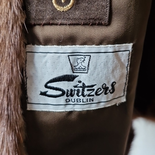 427 - A brown fur jacket with broad notched lapels and satin lining, bearing embroidered Grosvenor and Swi... 