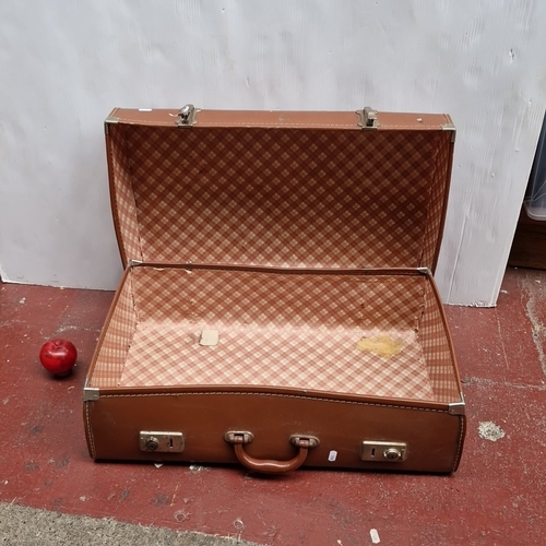 449 - A vintage brown suitcase with stitched exterior, twin clasps and central handle, the interior lined ... 