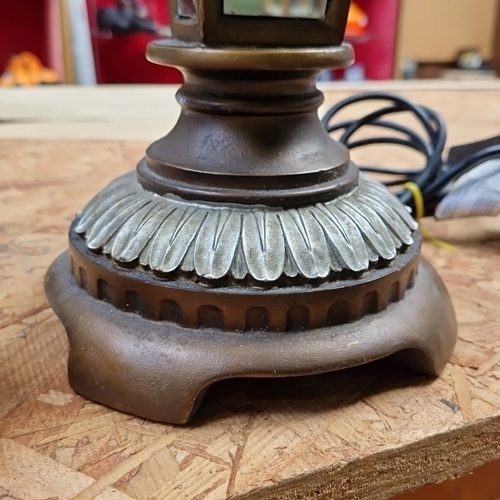 457 - A large cast-metal table lamp in the form of a glazed lantern, with fluted galleries and an ecru bel... 