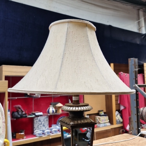 457 - A large cast-metal table lamp in the form of a glazed lantern, with fluted galleries and an ecru bel... 