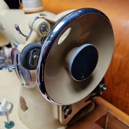 459 - A very clean cream Union electric sewing machine in cream enamelled metal, housed in a wooden carry ... 