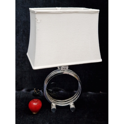 470 - A modern chrome table lamp, the circular openwork base formed of concentric rings on twin feet, with... 