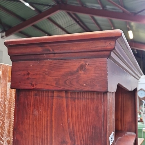 482 - A tall pine open bookcase, the moulded cornice with scalloped apron above a boarded back and five ad... 