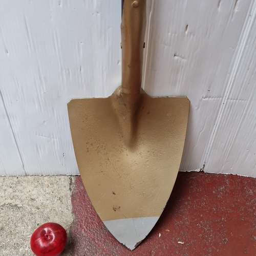 483 - A long-handled spade, the metal blade painted in a gold tone with a pointed steel cutting edge, on a... 