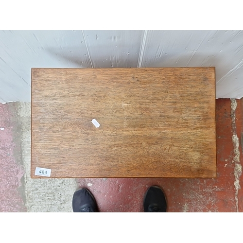 484 - A small oak occasional table, the rectangular top with rounded corners raised on turned tapering leg... 