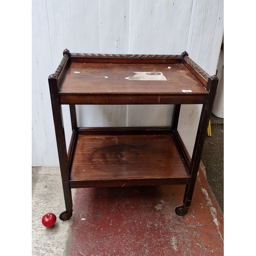 485 - A mahogany two-tier trolley table, with three-quarter gallery top carved with leaf-scroll and rosett... 
