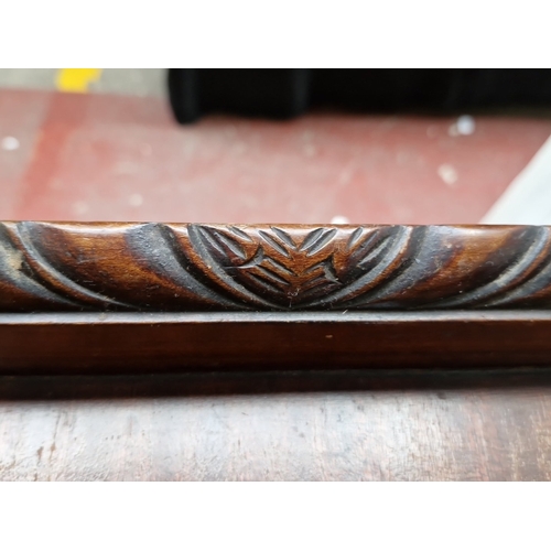 485 - A mahogany two-tier trolley table, with three-quarter gallery top carved with leaf-scroll and rosett... 