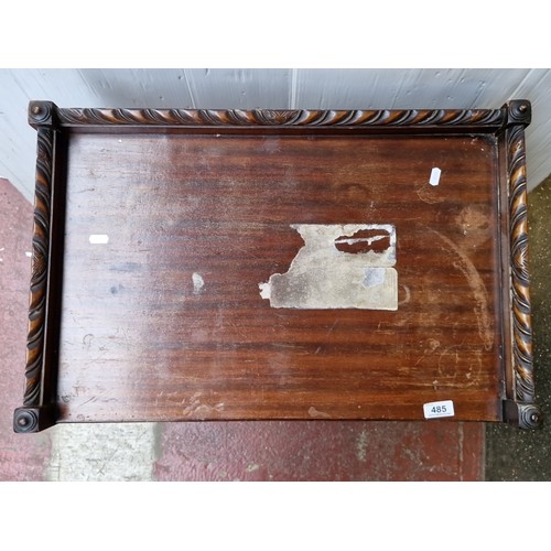 485 - A mahogany two-tier trolley table, with three-quarter gallery top carved with leaf-scroll and rosett... 