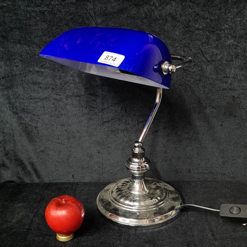A chrome-effect banker’s desk lamp with domed blue shade on adjustable arm and circular weighted base, wired for mains power; label to underside.