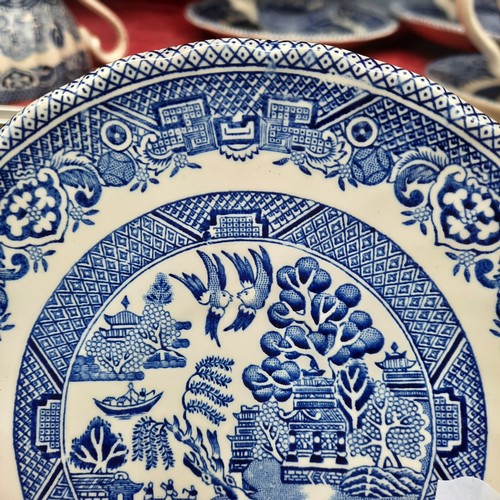 416 - A group of Churchill Blue Willow pattern blue-and-white tableware, including cups and saucers, dinne... 
