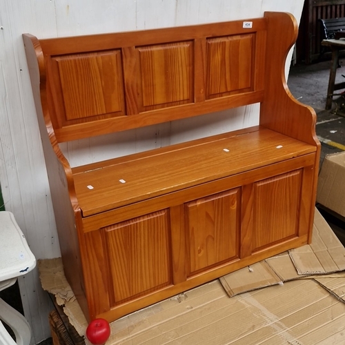 A pine settle-style hall bench with lift-up seat enclosing storage, the ...