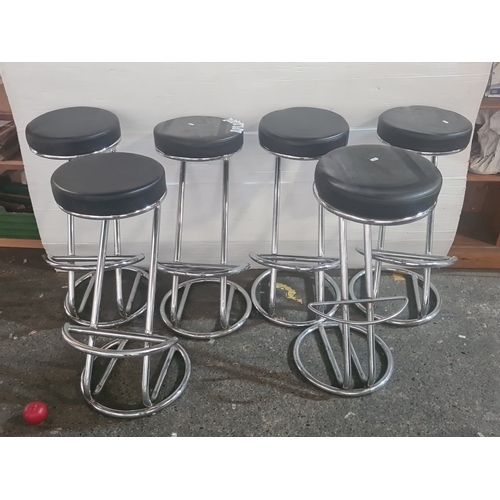 A group of 6 chrome-plated bar stools with round black upholstered ...