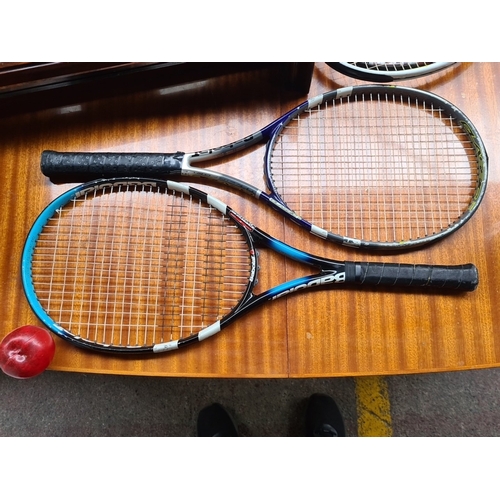 A group of tennis equipment comprising four graphite tennis racquets, a ...