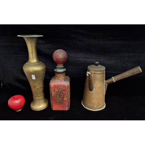 141 - Three vintage items including an Italian leather bound glass decanter, an engraved brass vase and a ... 