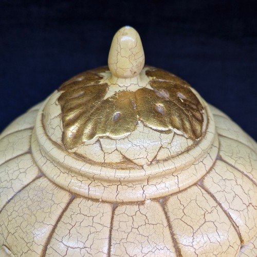 161 - A large decorative ceramic vase with a lid featuring a distinct cream-coloured crackle glaze, gilded... 