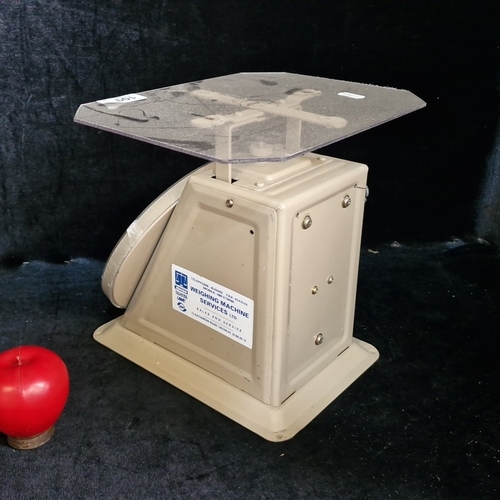 1572 - Ishida mechanical postal scale, the circular dial calibrated to 1000g with red indicator, set on a p... 