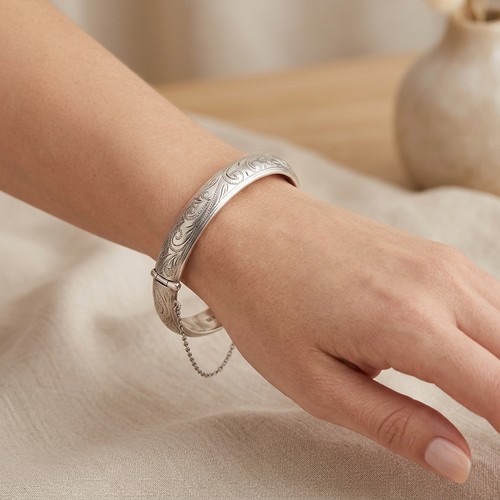 17 - A Sterling Silver vintage bangle bracelet set with incised detailing. Hallmarked Birmingham with saf... 
