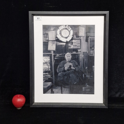 87 - A photographic print featuring a figure in a room filled with amateur radio memorabilia. Housed in a... 