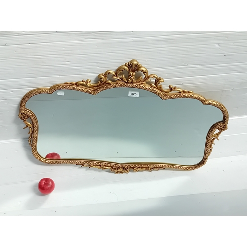 370 - A gilt ornate Rococo style wall mirror featuring detailed scroll and floral carvings. MM - 86CM X 60... 
