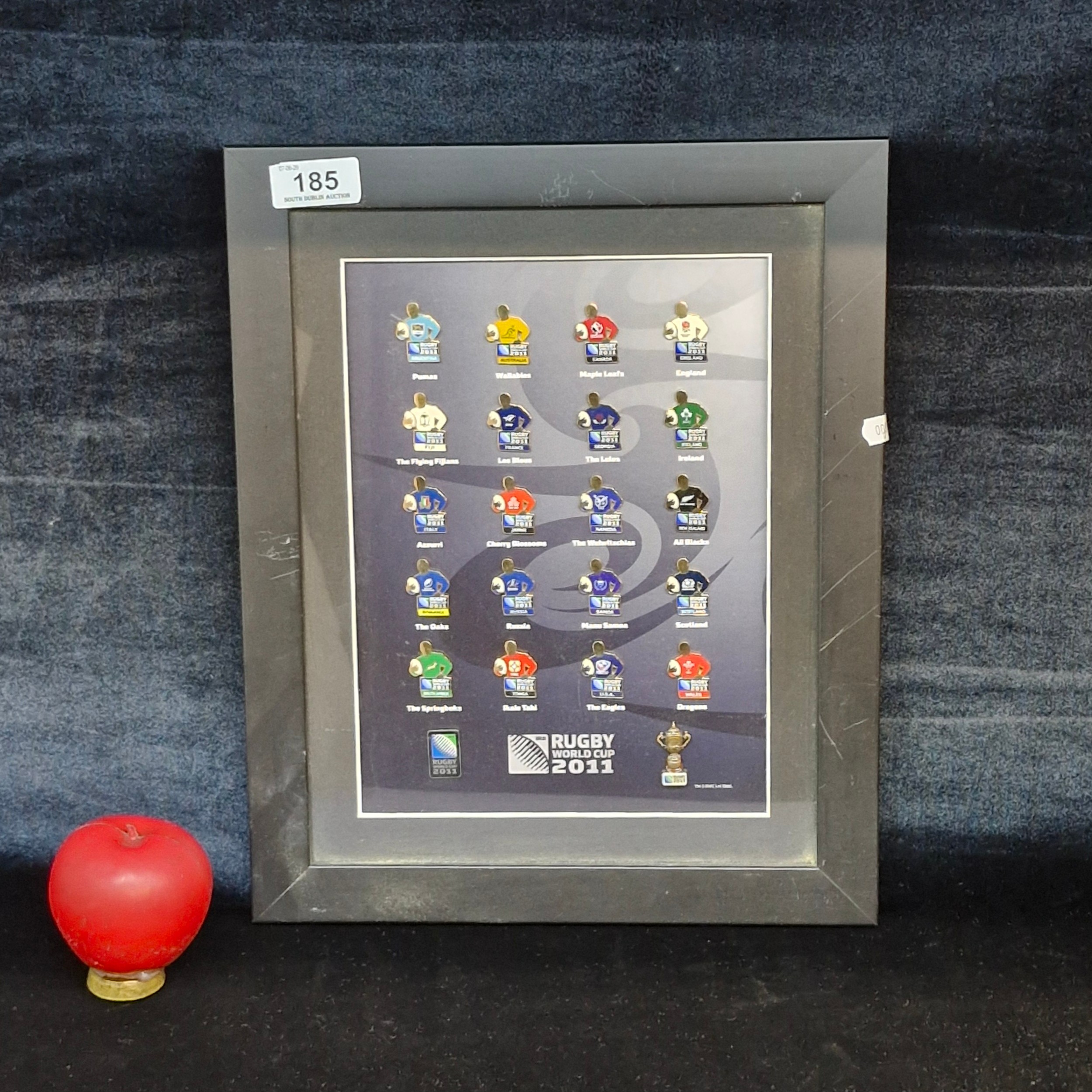 A framed collection of team enamel pins from the 2011 Rugby World Cup ...