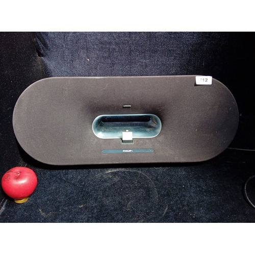 Philips tabletop iPhone docking speaker system, model DS9000/12, with oval fabric-covered enclosure, central dock bay and touch volume controls; wood-veneered underside with twin bass ports, manufacturer’s label and power lead. With the modern iphone attachement.