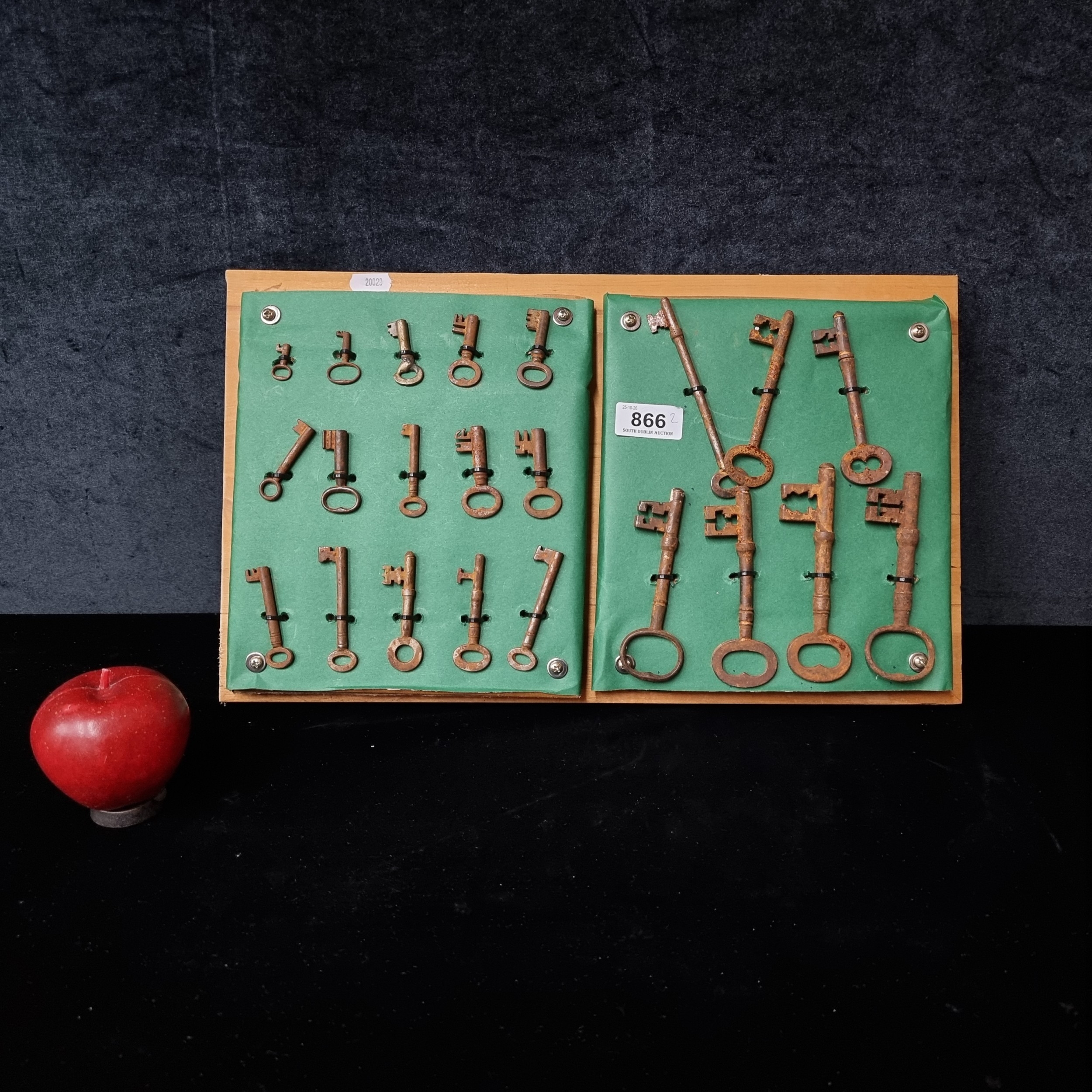 A selection of antique skeleton keys and old iron keys mounted on board ...