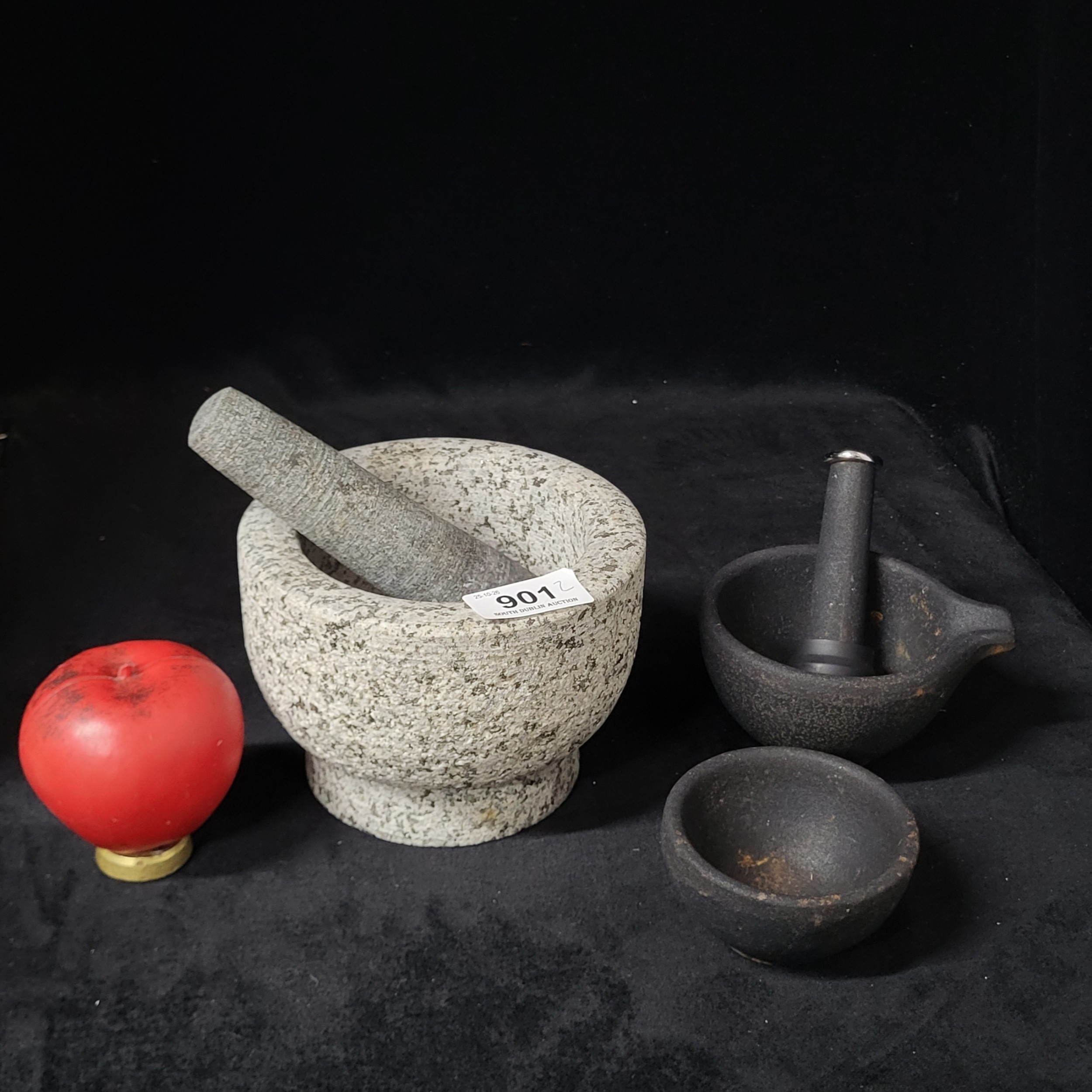 A very heavy granite mortar and pestle along with two smaller cast iron ...