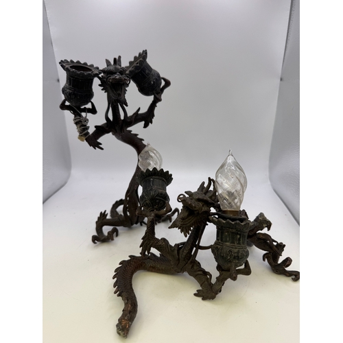 13 - Pair of antique Japanese cast metal twin-light candlesticks in the form of dragons, 11cm high (one A... 