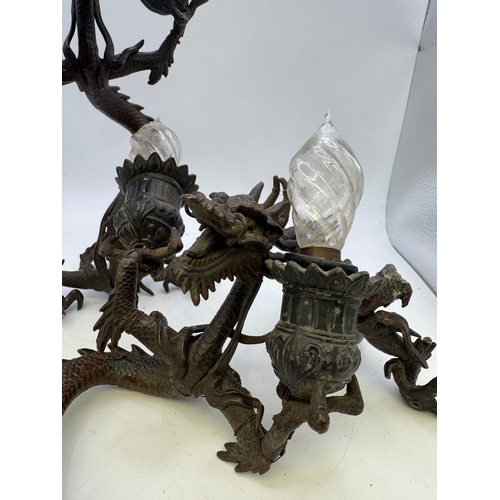 13 - Pair of antique Japanese cast metal twin-light candlesticks in the form of dragons, 11cm high (one A... 