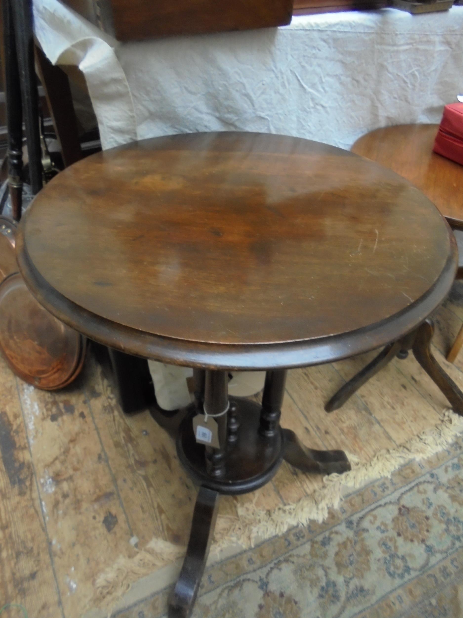 Larger circular topped dark oak side table, the splayed tricorn base