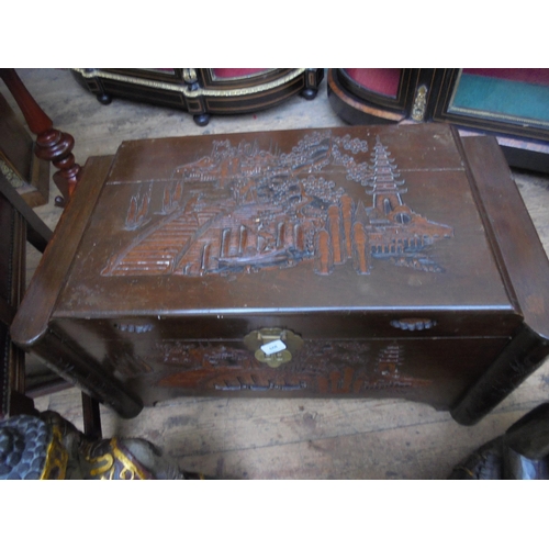 668 - Heavily carved camphor wood chest with carved design to front and top with pagoda's and other scenes