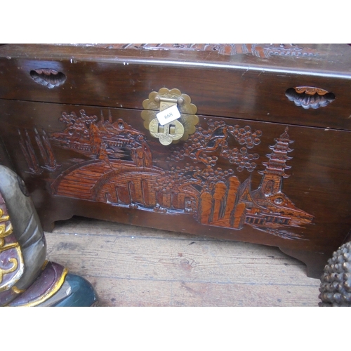 668 - Heavily carved camphor wood chest with carved design to front and top with pagoda's and other scenes