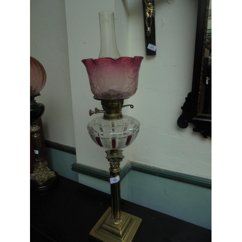 682 - A fine brass single oil lamp, column design with cut glass oil holder and cranberry styled glass sha... 