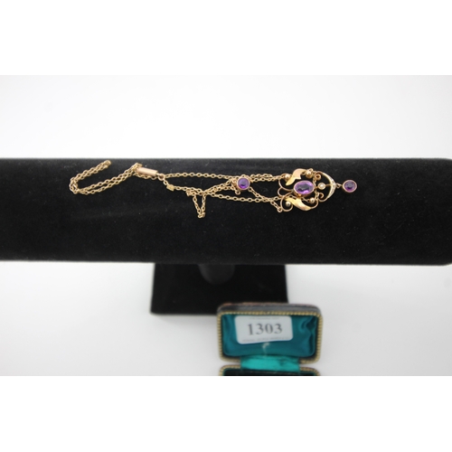 1303 - 9ct gold oval pendant inset with 3 purple sapphires