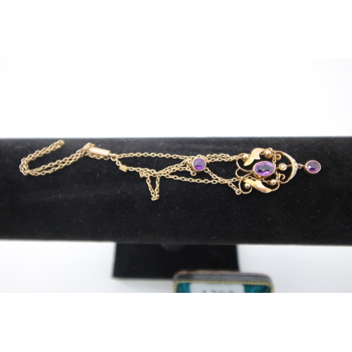 1303 - 9ct gold oval pendant inset with 3 purple sapphires