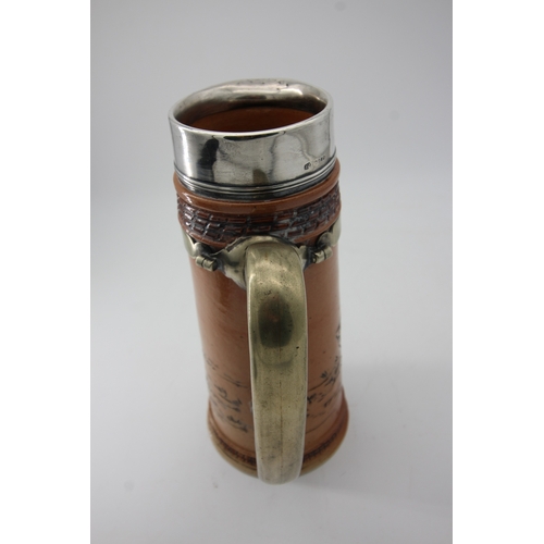 1334 - Doulton stoneware decorative jug having silver rimmed top and brass handle (some damage to base)