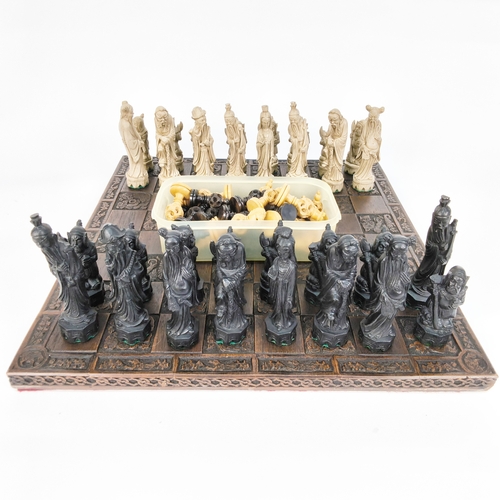 51 - A turned wood chess set and a resin Oriental designed set with chess board