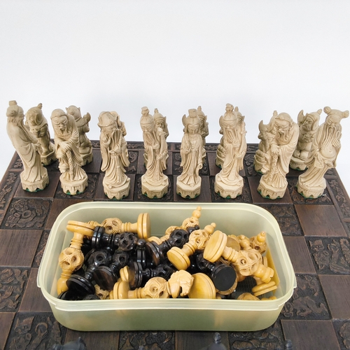 51 - A turned wood chess set and a resin Oriental designed set with chess board