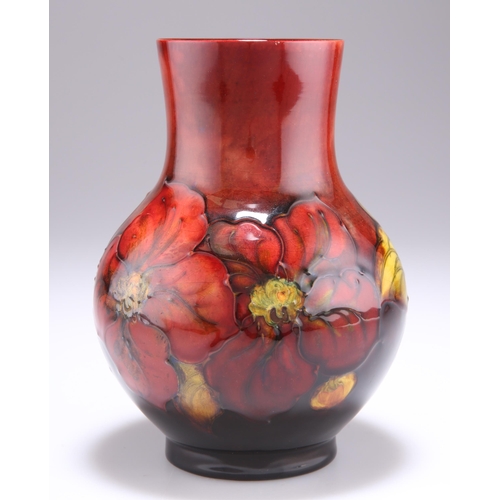 54 - WALTER MOORCROFT AN ANEMONE PATTERN FLAMBÉ POTTERY VASE, baluster form with a long flared neck, tube... 