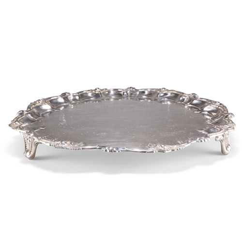 1002 - A LARGE VICTORIAN SILVER-PLATED SALVER, by Johnson & Co, Birmingham, c.1879-99, shaped circular. 43m... 